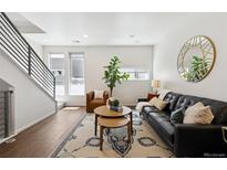 Bright living room featuring modern decor, a large window, and a sleek staircase at 1711 Hooker St # 2, Denver, CO 80204
