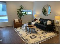 Stylish living room boasts a black leather sofa, area rug, and decor, creating a comfortable and inviting space at 1711 Hooker St # 2, Denver, CO 80204