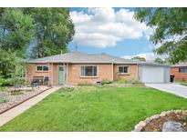Charming brick home with a well-manicured lawn, walkway, and green front door at 9150 Fir Dr, Thornton, CO 80229