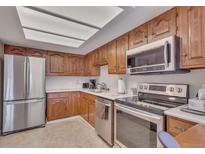 Cozy kitchen features stainless steel appliances, ample wood cabinets, and bright lighting at 13931 E Marina Dr # 402, Aurora, CO 80014