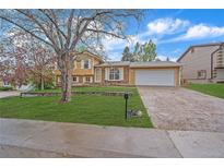 Charming single-Gathering home with a well-maintained front yard, mature tree, and driveway leading to a two-car garage at 2166 S Joplin Way, Aurora, CO 80013
