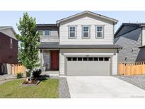 Charming two-story home with a well-maintained lawn, red front door, and a two car garage at 6117 Easton Cir, Frederick, CO 80504