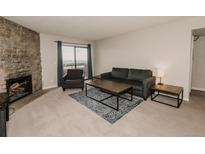 Cozy living room with a stone fireplace and sliding glass door with a view of the sky at 431 Wright St # 203, Lakewood, CO 80228