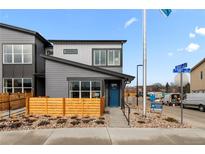 Modern two-story home boasting a blue door, wood fencing, and professional landscaping at 9487 W 58Th Ln # C, Arvada, CO 80002