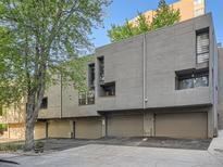 Modern townhome featuring a concrete exterior and attached garages, set against a backdrop of mature trees at 1070 Race St # H, Denver, CO 80206