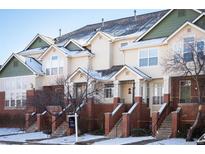 Charming townhome exterior with brick accents, inviting entryway, and snowy landscape, offering curb appeal and a welcoming atmosphere at 9763 E Carolina Pl, Aurora, CO 80247