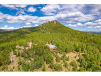 Stunning aerial view of a mountain property with a barn, trees, and a picturesque landscape at 8838 Hillview Rd, Morrison, CO 80465