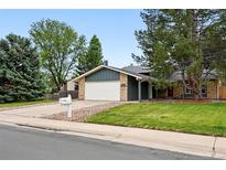 Charming single-Gathering home featuring a manicured lawn, brick accents, and an attached two-car garage at 2495 S Lansing Way, Aurora, CO 80014
