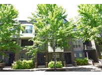 Inviting townhome exterior with brick accents, lush greenery, and mature shade trees at 451 S Reed St, Lakewood, CO 80226