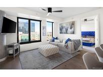 Bright living room featuring large windows, comfortable seating, and a modern ceiling fan at 1750 Wewatta St # 1521, Denver, CO 80202
