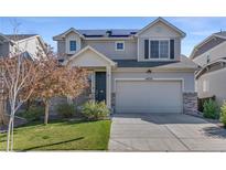Inviting two-story home with a well-maintained lawn and a two-car garage with grey sidings at 18079 E 108Th Pl, Commerce City, CO 80022