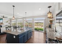 Bright kitchen features stainless steel appliances, granite countertops, and an island with pendant lighting at 18079 E 108Th Pl, Commerce City, CO 80022