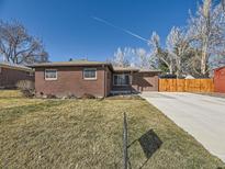Charming brick ranch home with a well-maintained lawn and a long driveway leading to a garage at 3361 W Saratoga Ave, Englewood, CO 80110