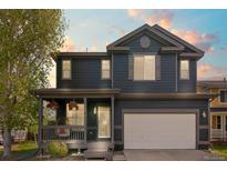 Charming two-story home featuring a cozy front porch and well-maintained lawn at 5249 Mt Arapaho Cir, Frederick, CO 80504