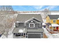 Charming gray two-story home with a front porch and attached garage, perfect for suburban living at 5249 Mt Arapaho Cir, Frederick, CO 80504