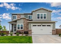 Charming two-story home with gray siding, stone accents, and a well-maintained front yard at 6990 E 132Nd Pl, Thornton, CO 80602