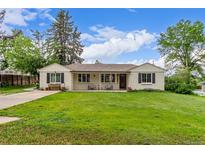 Charming one-story home featuring a well-manicured lawn and inviting covered porch at 3865 Independence Ct, Wheat Ridge, CO 80033