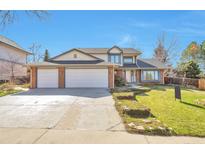 Charming two-story home featuring a brick facade, a three-car garage and a well-manicured front yard at 8055 S Zephyr Way, Littleton, CO 80128