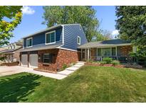 Charming two-story home featuring brick accents, attached two car garage, and a lush green front yard at 3767 E Phillips Cir, Centennial, CO 80122