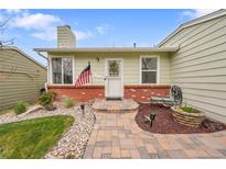 Charming home with brick accents, a colorful walkway, and a manicured front yard at 4856 S Quintero Cir, Aurora, CO 80015