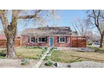 Charming single-story brick home with a well-manicured front yard, walkway, and privacy fence at 7785 E 13Th Ave, Denver, CO 80220