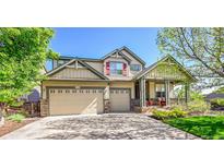 Charming two-story home featuring a welcoming front porch and a spacious three-car garage at 10565 Kicking Horse Dr, Littleton, CO 80125