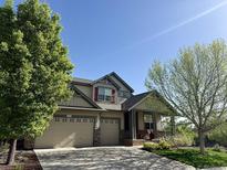 Inviting two-story home featuring a three-car garage and a charming front porch, perfect for relaxing outdoors at 10565 Kicking Horse Dr, Littleton, CO 80125