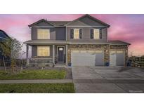 Two-story home showcasing a covered front porch and three-car garage at 7702 E 159Th Ave, Thornton, CO 80602
