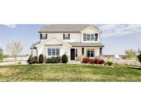 Charming two-story home features a manicured lawn and lovely landscaping at 16300 Paris Way, Brighton, CO 80602