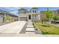 Charming two-story home featuring a welcoming porch and landscaped front yard with a concrete staircase at 3888 Grand Baker St, Aurora, CO 80019