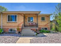 Charming brick home featuring a cozy front porch and well-maintained landscaping at 3818 W 25Th Ave, Denver, CO 80211