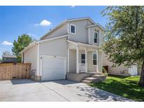 Charming two-story home with a well-maintained front yard, driveway, and attached one-car garage on a sunny day at 1232 Bluebird St, Brighton, CO 80601