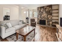 Cozy living room features a stone fireplace, hardwood floors, and comfortable seating at 13645 E Yale Ave # C, Aurora, CO 80014