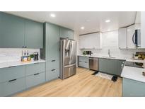 Modern kitchen featuring stainless steel appliances, two-tone cabinets, and a white subway tile backsplash at 6513 Gray St, Arvada, CO 80003