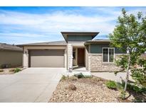 Charming single-Gathering home boasts a two-car garage, stone accents, and a well-maintained landscaped front yard at 10786 Bear Cub Dr, Broomfield, CO 80021