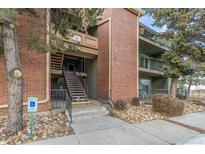 Multi-level condo building with brick accents, stone landscaping, and stairway entrances at 4899 S Dudley St # 18A, Littleton, CO 80123