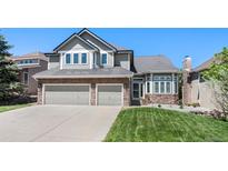 Charming two-story home featuring a two-car garage, well-manicured lawn, and stone accents at 85 Willowleaf Dr, Littleton, CO 80127
