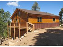 Charming wood home featuring a spacious deck, offering great outdoor living and mountain views at 10178 Hutch Ln, Conifer, CO 80433