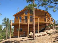 Attractive wood home with an expansive deck, perfect for enjoying the surrounding nature and scenery at 10178 Hutch Ln, Conifer, CO 80433