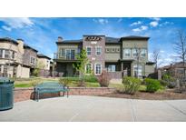 Inviting home featuring a landscaped lawn, charming brick accents, and a cozy front patio with comfortable seating at 924 Brookhurst Ave # C, Highlands Ranch, CO 80129