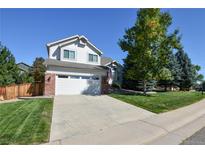 Charming two-story home features a manicured front yard, attached garage, and classic architectural details at 7641 Lebrun Ct, Lone Tree, CO 80124