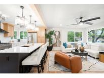 Bright, open-concept living room with modern finishes, a spacious island, and stainless-steel appliances at 6512 Upham St, Arvada, CO 80003