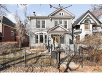 Charming gray two-story home featuring a well-kept front yard and decorative black iron fence at 2823 N Lafayette St, Denver, CO 80205