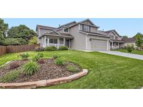 Charming two-story home with a well-manicured lawn and attractive landscaping at 1641 Cedarwood Dr, Longmont, CO 80504