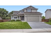 Traditional two-story home boasts a two-car garage and manicured front lawn at 1641 Cedarwood Dr, Longmont, CO 80504
