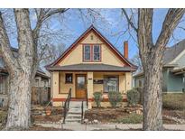 Charming, colorful two-story home with gabled roof, covered front porch, and landscaped yard at 1460 S Grant St, Denver, CO 80210