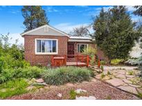 Charming brick home with a inviting front porch and well-maintained landscaping, offering curb appeal at 4730 Pierce St, Wheat Ridge, CO 80033