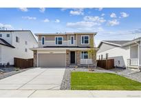 Charming two-story home featuring manicured lawn, stone accents, and a spacious two-car garage at 45934 Gentry Ave, Bennett, CO 80102