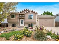 Charming two-story home with well-maintained landscaping, tan siding, and inviting front door entrance at 1482 S Pitkin Cir, Aurora, CO 80017