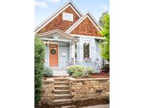 Charming home featuring a quaint front yard with stone retaining wall and colorful, peach-colored front door at 3425 W 34Th Ave, Denver, CO 80211